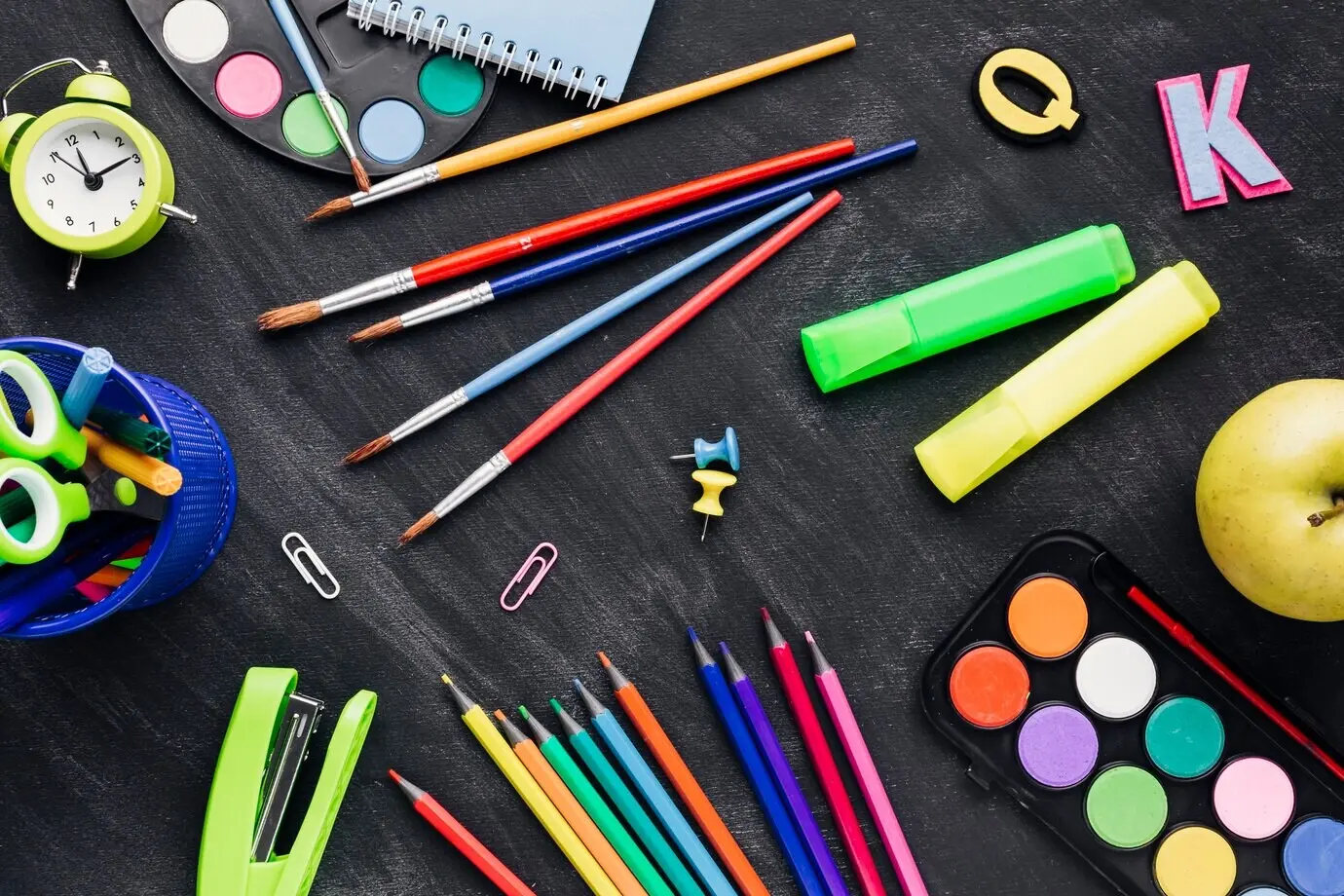 Mehrfarbige, durcheinanderliegende Schreibwaren auf grauem Hintergrund