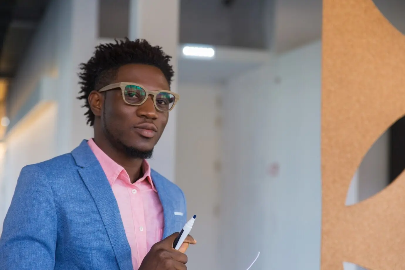 Ernsthafter männlicher Designer, der einen Marker hält und posiert.